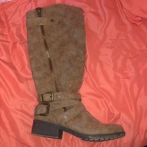 Tan boots with a buckle and zipper detail